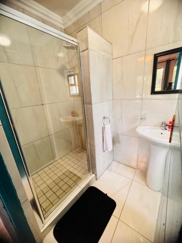 a bathroom with a shower and a sink at Unogwaja Rest in Marloth Park