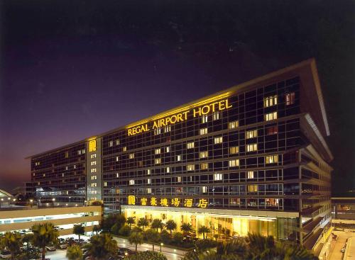 a hotel building with a sign on it at night at Regal Airport Hotel in Hong Kong