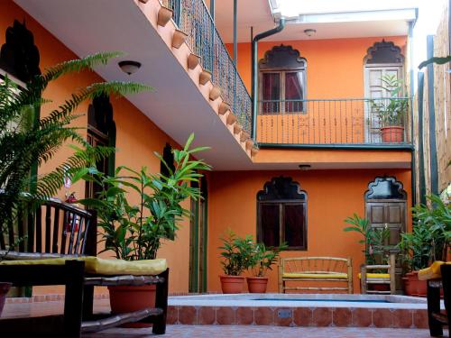 an orange building with a staircase and plants at Boutique Hotel Maharaja in Granada