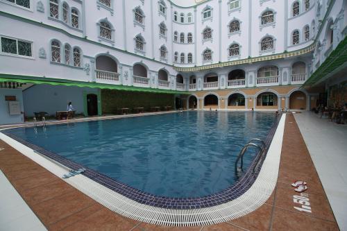 a large swimming pool in a large building at Takhmao Good Health Hotel in Ta Khmau