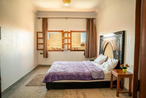 a bedroom with a bed and a window at Appartement City Center in Ouarzazate
