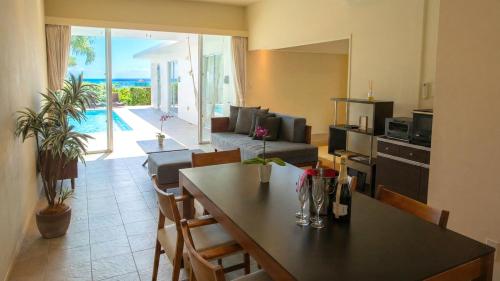 a kitchen and living room with a table and a living room at Feliz Villa Suite Miyakojima Ueno in Miyako-jima