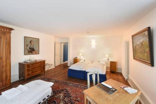 a bedroom with a bed and a table and a couch at Hotel im Schlosspark in Basel