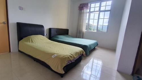 two beds in a room with a window at Green View Home Cameron Highlands in Brinchang