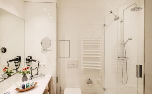 a white bathroom with a shower and a toilet at Best Western Comfort Business Hotel Düsseldorf-Neuss in Neuss