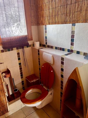 a bathroom with a toilet with a red lid at Comme à la maison à la montagne in Briançon