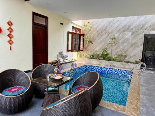 a pool with chairs and a table next to a swimming pool at De' Mon Villa in Làng Tong Tchoung