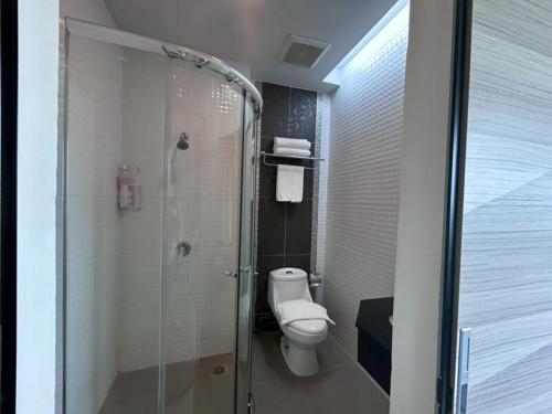 a bathroom with a toilet and a glass shower at Chiang Rai Airport Hotel in Ban Fang Min