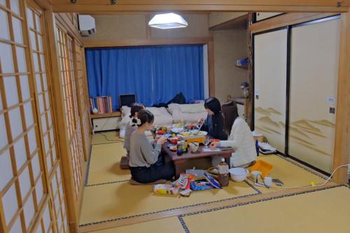 a group of people sitting around a table eating food at 古民家宿Tabi湊 in Hitachinaka
