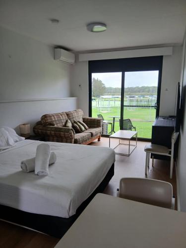 a room with two beds and a living room with a couch at Waterview Motel Sussex Inlet in Sussex inlet