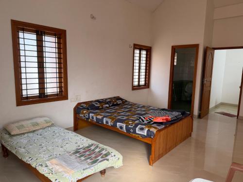 a bedroom with two beds and a bed and a window at Serenity Springs in Mysore