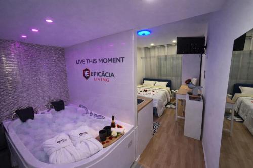 a room with two beds and a tub with towels at Spa & Jacuzzi Dupla Privada Escapadinha Romântica Abrantes in Abrantes