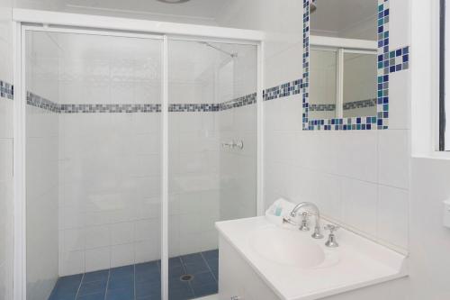 a white bathroom with a sink and a shower at Sunshine Beach Resort in Gold Coast