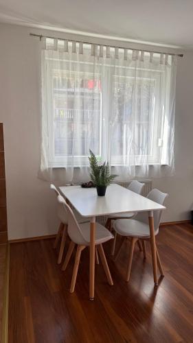 Una mesa y sillas blancas en una habitación con ventana. en Lena, en Jajce