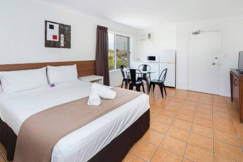 een hotelkamer met een bed en een tafel met stoelen bij Sunshine Beach Resort in Gold Coast
