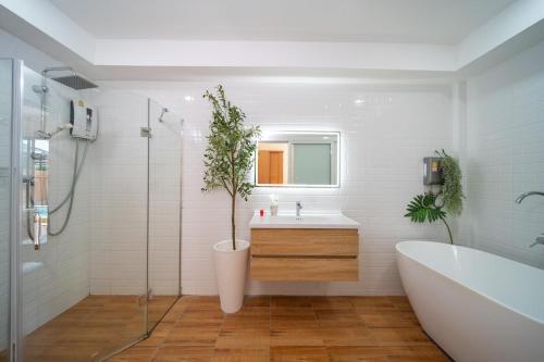 a bathroom with a tub and a sink and a plant at Mango Breeze Villa in Ban Nong Chaeng