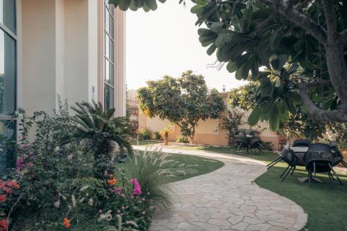 a garden with flowers and tables and a building at Full Moon Guesthouse in Dubai