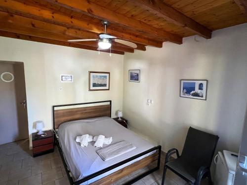 a bedroom with a bed with a fan and a chair at Poraika studios in Raches