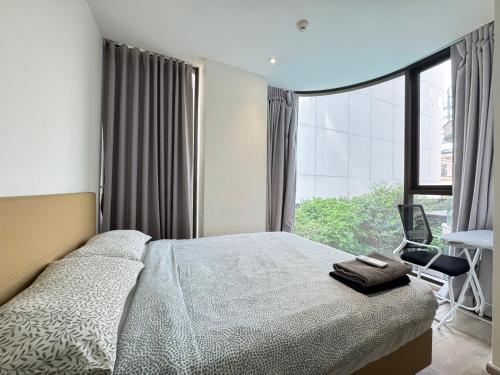 a bedroom with a bed and a large window at Fynn Bangkok Asoke Condo in Bangkok