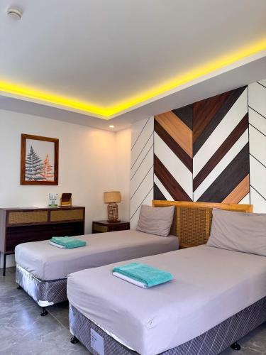two beds in a room with two tables at Red Picnic Hostel Panglao in Panglao Island