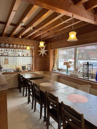 a dining room with a large wooden table and chairs at Polar Bear 藏王白熊民宿 in Kaminoyama