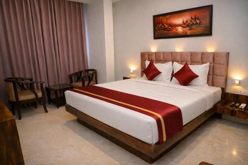 a hotel room with a large bed with red pillows at Hotel Prowell Apex - Kondapur in Hyderabad