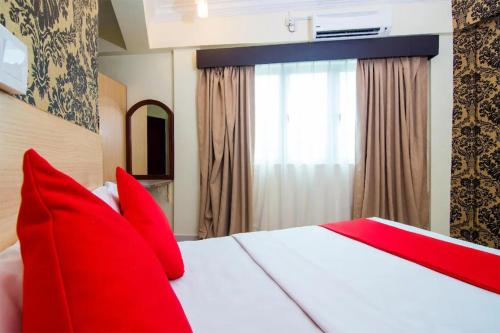 a red bed with red pillows in a room at Hotel D'Sea Princess in Tanjung Bungah