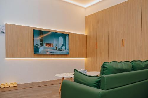 a living room with a green couch and a tv at Hotel Koperasi in Seria