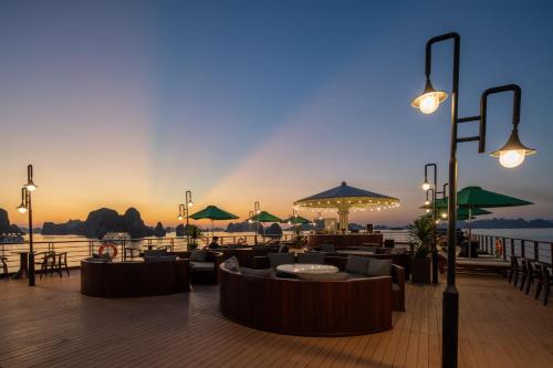 a restaurant with couches and umbrellas on a pier at Cycad cruise in Ha Long