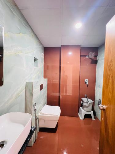 a bathroom with a toilet and a sink at Hotel Royal Manor in Rajkot