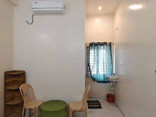 a bathroom with two chairs and a sink and a table at AalaGo in Thiruchendur