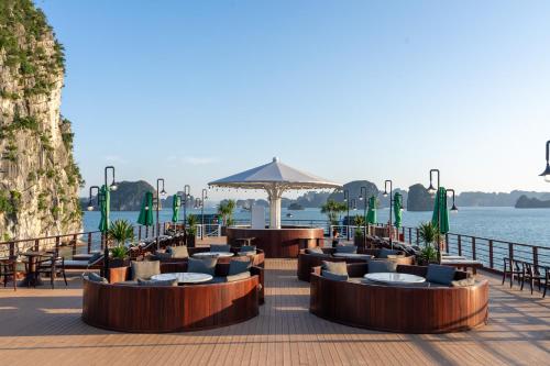 a restaurant with tables and chairs next to the water at Cycad cruise in Ha Long