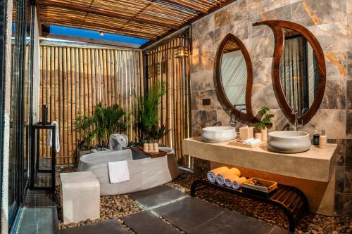 a bathroom with two sinks and a mirror at Amiana Resort Cam Ranh in Cam Ranh