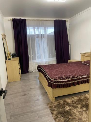 a bedroom with a bed and a large window at Dos in Kapchagay