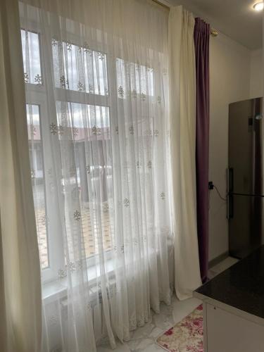 a room with a window with white curtains at Dos in Kapchagay