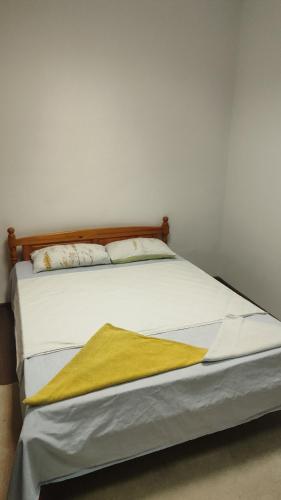 a bed with a yellow blanket on top of it at Апартамент Луиза in Varna City
