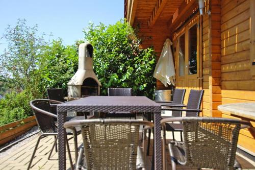 a table and chairs on a porch with a vase at Blockhaus, Bad Sachsa in Steina