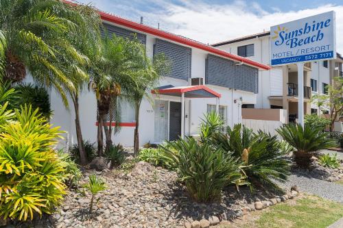a building with palm trees in front of it at Sunshine Beach Resort in Gold Coast