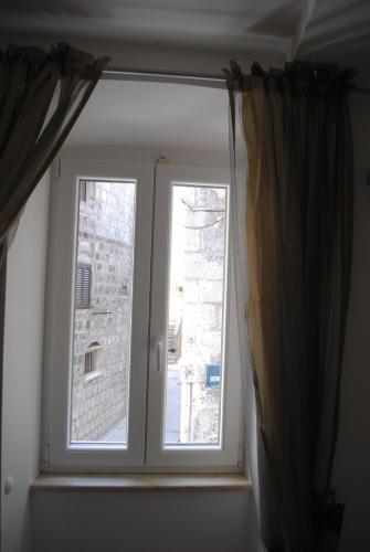 a window with a view of a building at Rooms Piazzetta in Cres