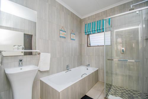 a bathroom with a tub and a sink and a shower at Glen Maine Guest House in Pretoria