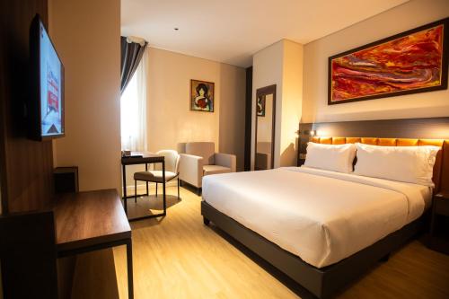 a hotel room with a bed and a flat screen tv at Hotel George in Cebu City