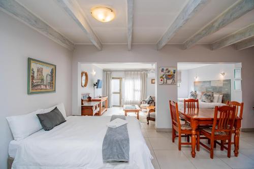 a bedroom with a bed and a table and chairs at Glen Maine Guest House in Pretoria