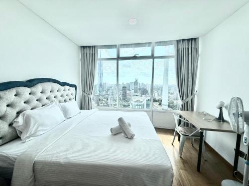 a bedroom with a bed with a desk and a window at Vortex Suites KLCC by Chia in Kuala Lumpur