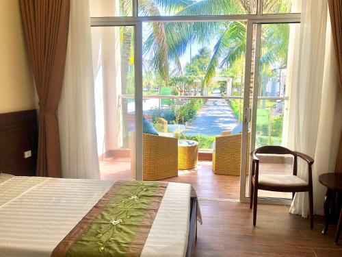 a bedroom with a bed and a view of a patio at Hải Tiến Resort in Mỹ Ðuc