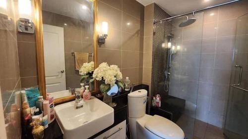 a bathroom with a sink and a toilet and a mirror at PoolView Condo Near MRT, Nice & Quiet, speedy net in Bangkok