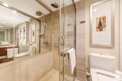 a bathroom with a glass shower and a toilet at Jianguo Hotel Xi'an in Xi'an