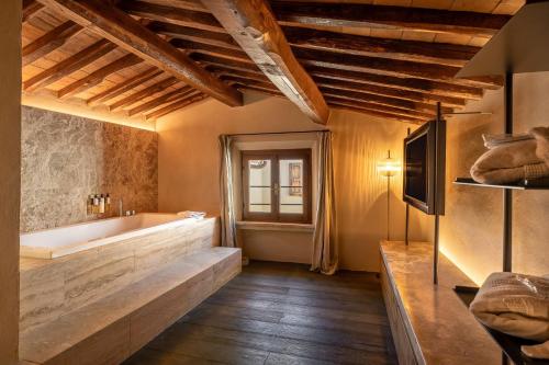 a bathroom with a large tub and a window at Mormoraia in San Gimignano