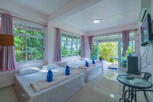 a living room with two beds and a table at Phuyafahsai The Resort Khao Kho in Khao Kho