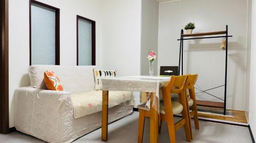 a living room with a table and a chair at サンハウス 2 in Osaka