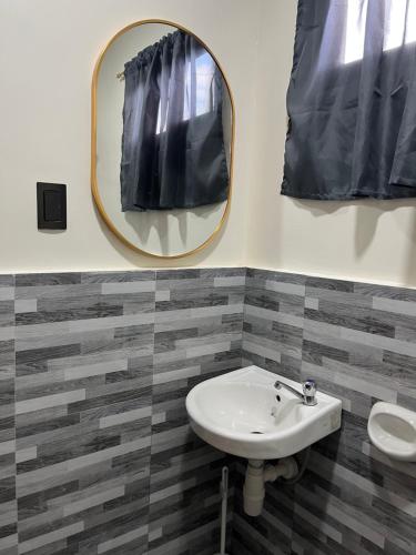 a bathroom with a sink and a mirror at Escubin Travellers Inn in San Miguel
